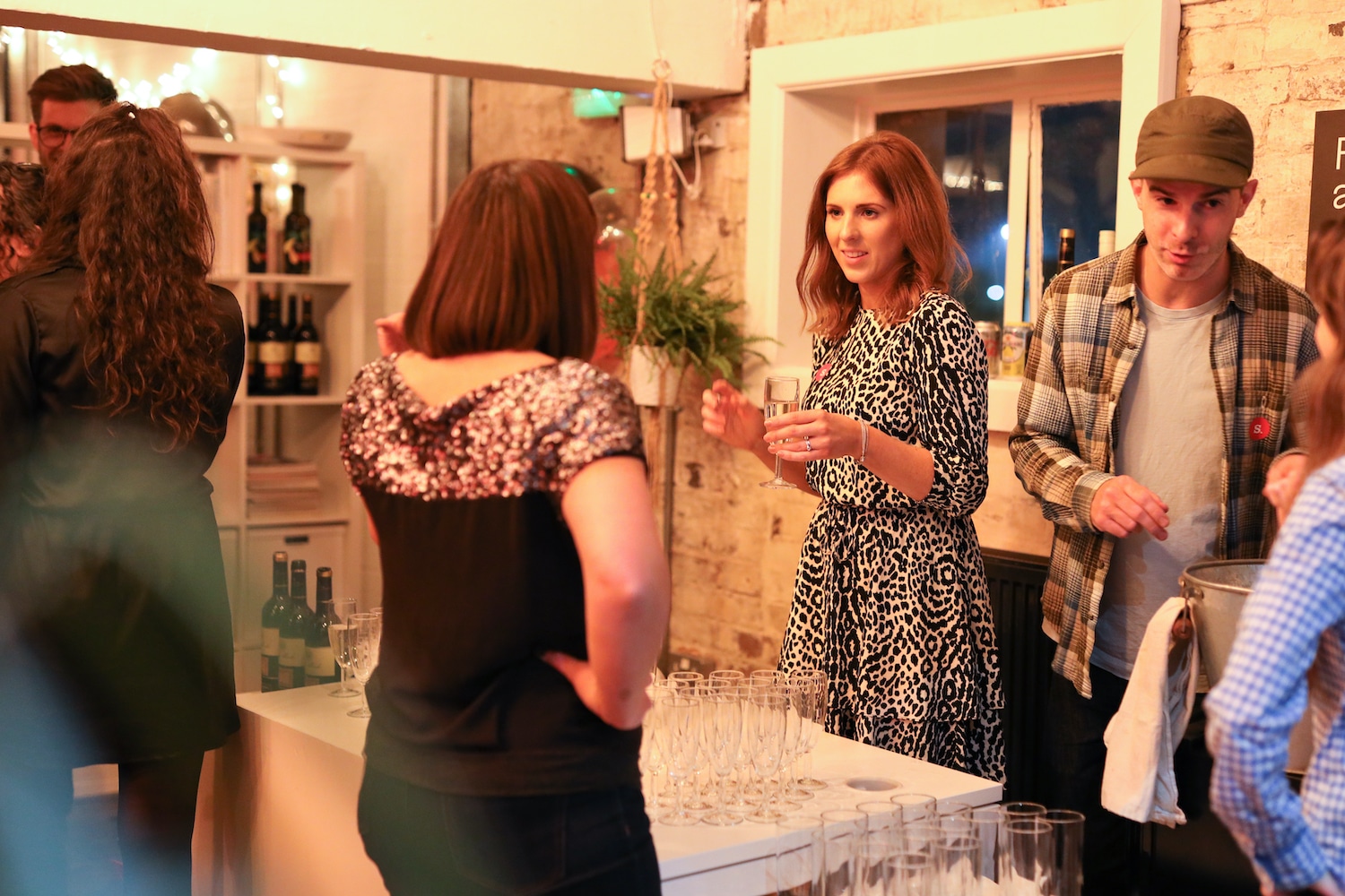 A woman handing a drink to a guest at the bar
