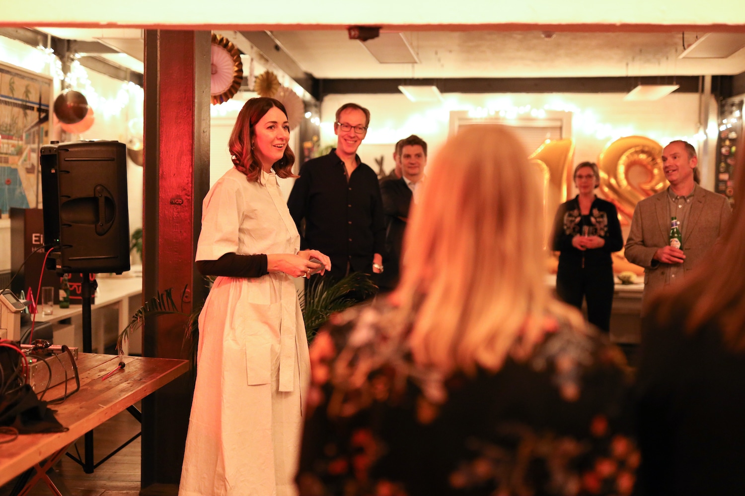 A woman talking to all of the party guests