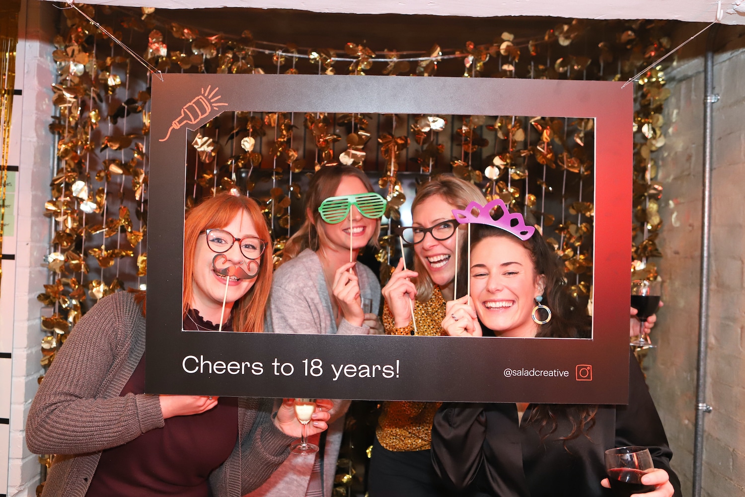 Four guests posing behind the photo frame